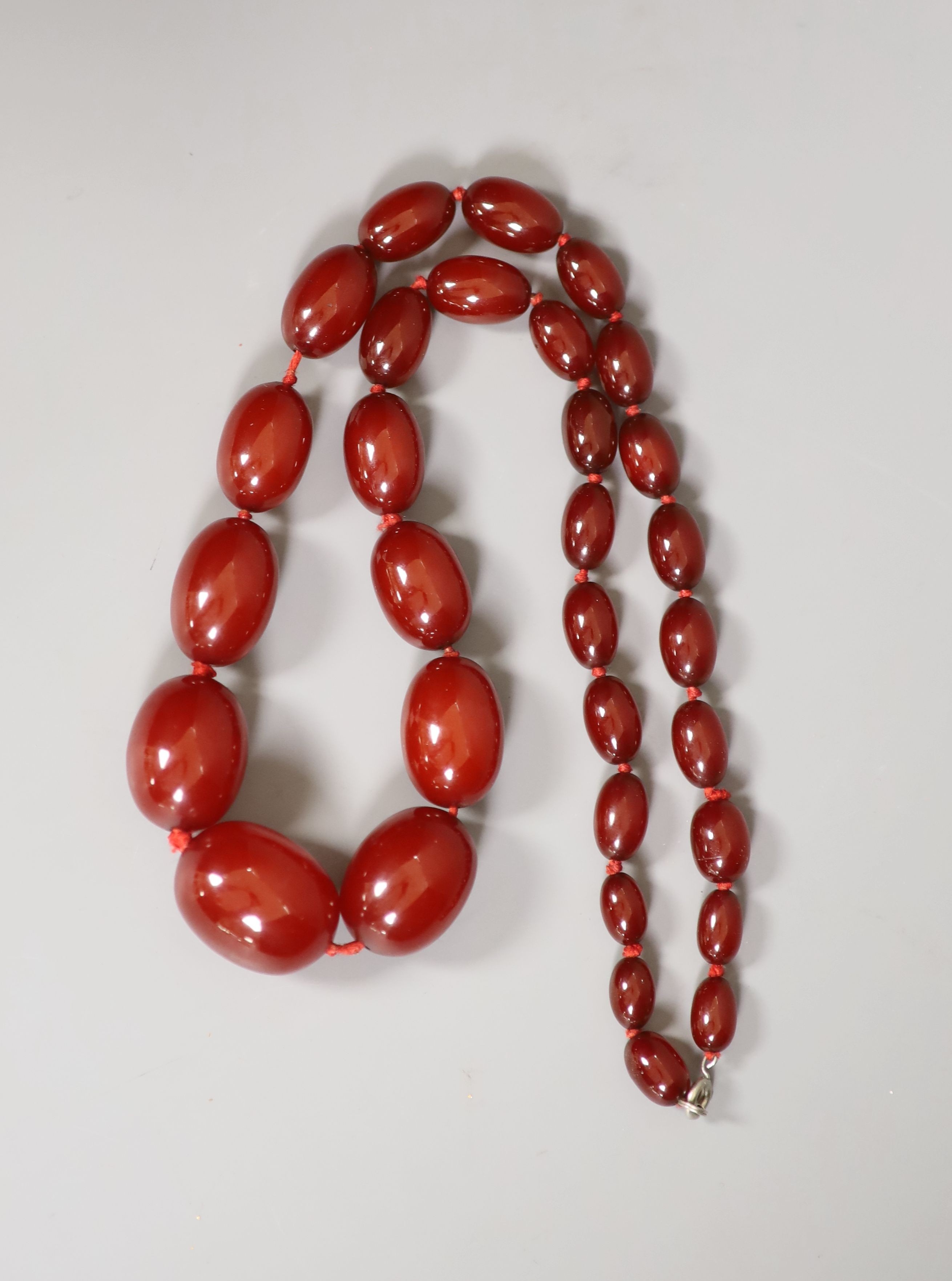 A single strand graduated simulated cherry amber necklace, 60cm, gross 69 grams.